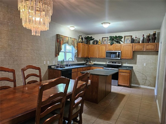 826 Oak Mill Ln, Imperial, MO 63052 - kitchen with stainless steel appliances, a sink, dark countertops, a chandelier, and light tile patterned flooring