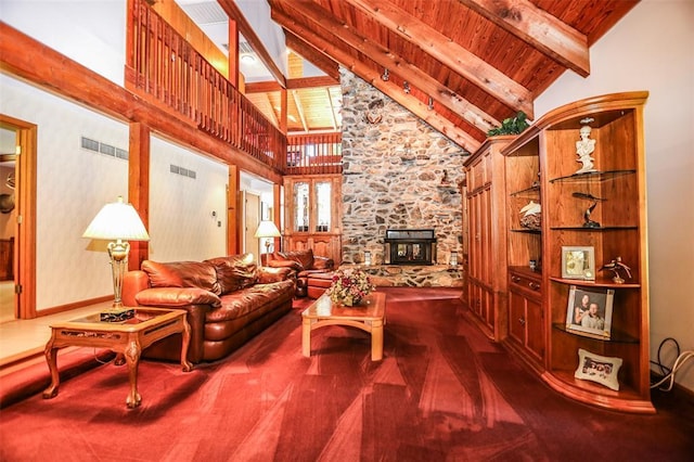 living room featuring high vaulted ceiling, wooden ceiling, beam ceiling, a stone fireplace, and dark colored carpet