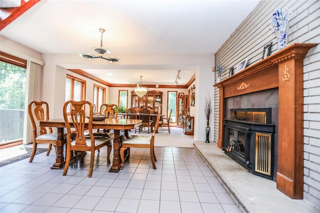 dining area with a chandelier, light tile patterned floors, and a fireplace