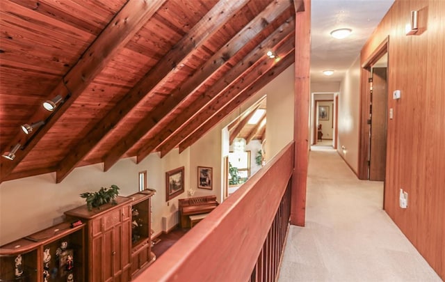 hall featuring light colored carpet, an upstairs landing, and wood ceiling