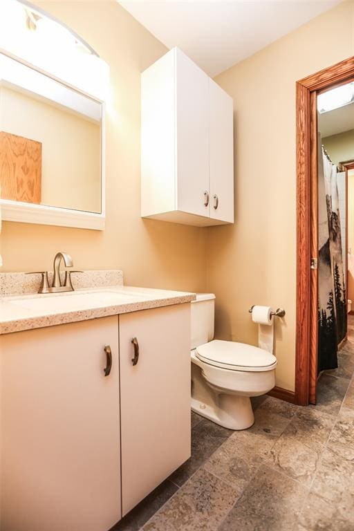 full bathroom with vanity, toilet, and stone finish floors