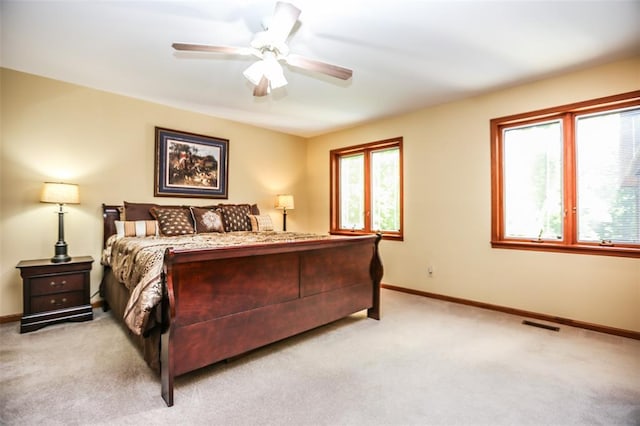 bedroom featuring light carpet, baseboards, and ceiling fan