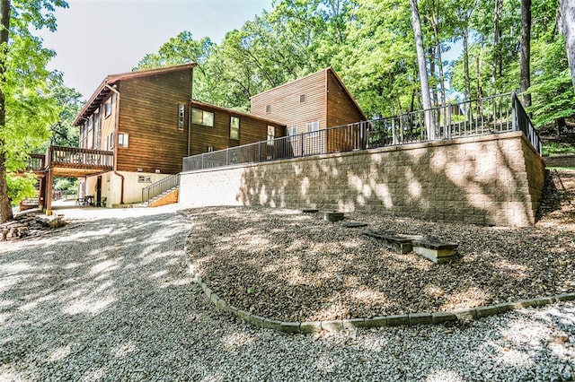view of property exterior featuring stairway and a wooden deck