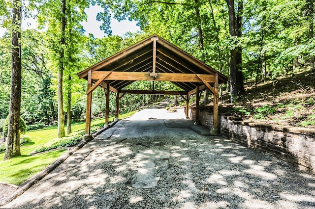 view of property's community with driveway and a detached carport