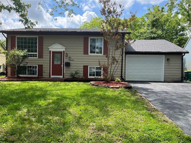 raised ranch with driveway, a garage, and a front yard