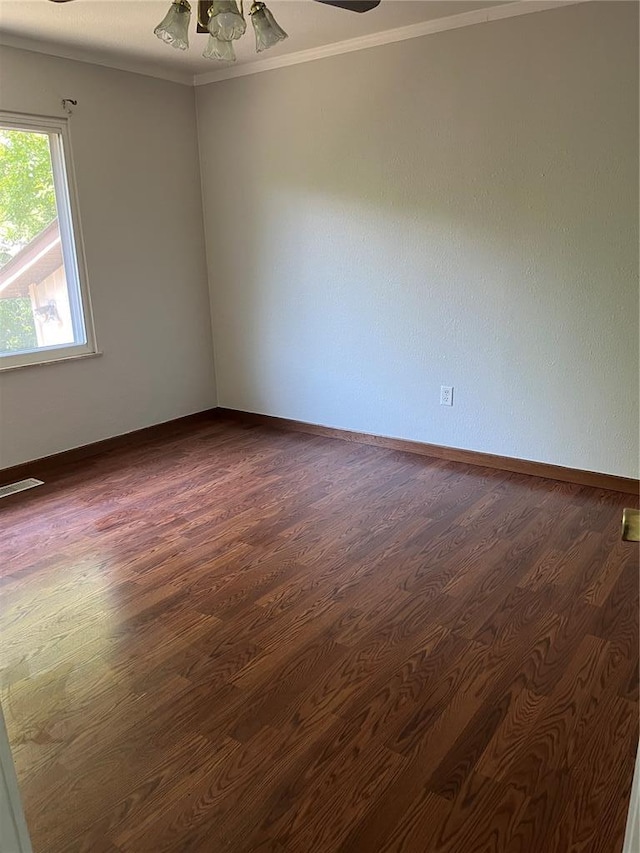 unfurnished room with ornamental molding, dark wood-style flooring, a ceiling fan, and baseboards