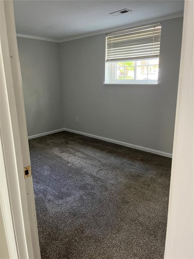carpeted empty room with crown molding and baseboards