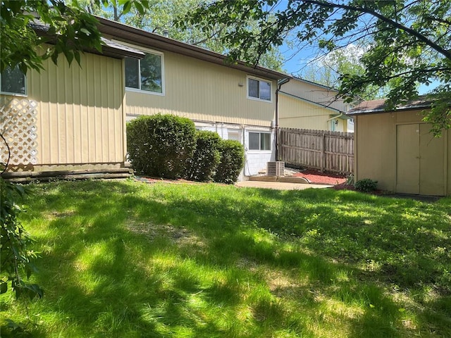rear view of house featuring a storage unit, an outdoor structure, and cooling unit