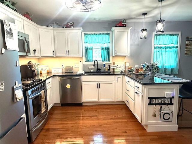 106 W Iowa St, Trenton, IL 62293 - kitchen with appliances with stainless steel finishes, a sink, a peninsula, dark countertops, and white cabinetry