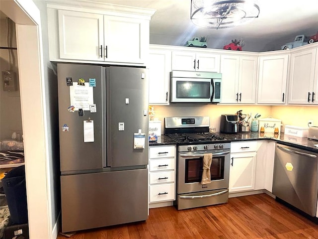 106 W Iowa St, Trenton, IL 62293 - kitchen featuring stainless steel appliances, white cabinetry, wood finished floors, and dark stone counters