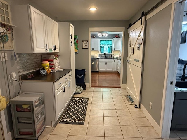 106 W Iowa St, Trenton, IL 62293 - kitchen featuring dishwasher, a sink, dark countertops, light tile patterned floors, and white cabinetry