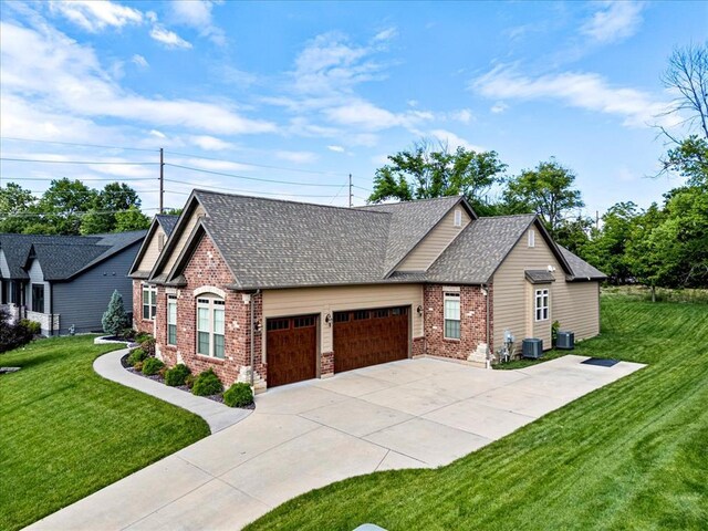 2604 Center Ave, Wildwood, MO 63040 - view of front of property featuring brick siding, a garage, a front yard, concrete driveway, and central air condition unit