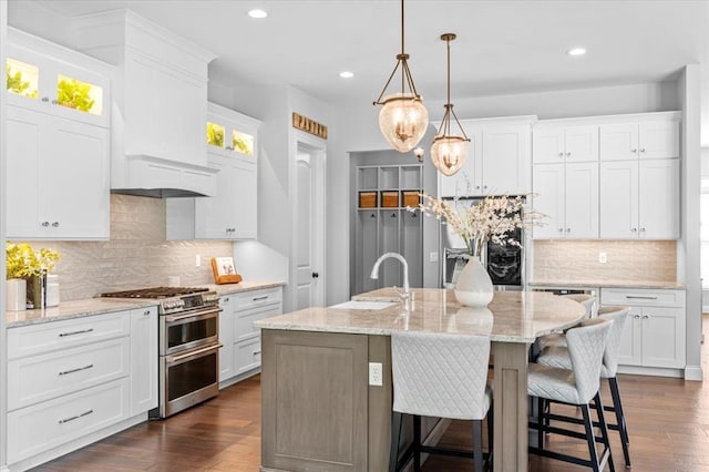 2604 Center Ave, Wildwood, MO 63040 - kitchen featuring appliances with stainless steel finishes, decorative backsplash, recessed lighting, dark wood-style flooring, and a center island with sink