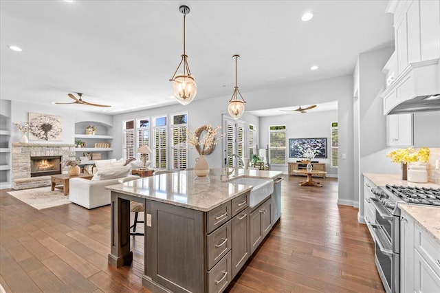 2604 Center Ave, Wildwood, MO 63040 - kitchen with a ceiling fan, a sink, open floor plan, range with two ovens, and white cabinetry