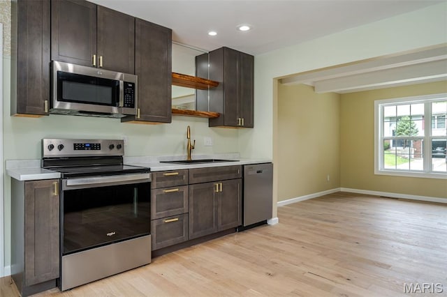 10 Jade Ln, Washington, MO 63090 - kitchen with appliances with stainless steel finishes, light wood-type flooring, light countertops, dark brown cabinetry, and recessed lighting