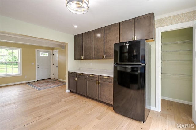 10 Jade Ln, Washington, MO 63090 - kitchen featuring freestanding refrigerator, dark brown cabinets, light wood finished floors, and light countertops