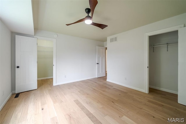 10 Jade Ln, Washington, MO 63090 - unfurnished bedroom featuring a walk in closet, a closet, light wood-style floors, and ceiling fan