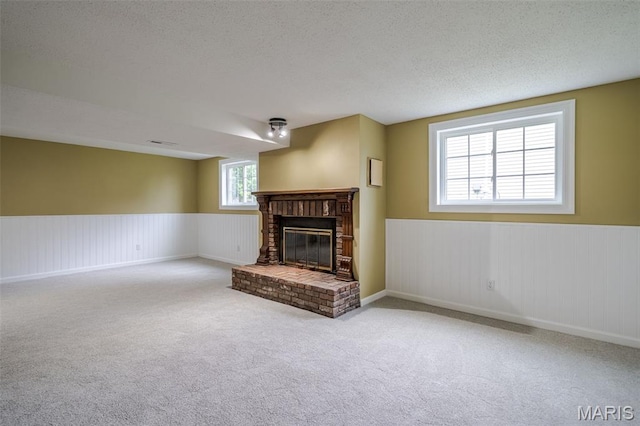 10 Jade Ln, Washington, MO 63090 - unfurnished living room with carpet flooring, wainscoting, a fireplace, and a textured ceiling