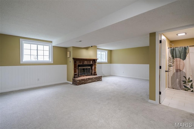 10 Jade Ln, Washington, MO 63090 - unfurnished living room featuring carpet, a fireplace, wainscoting, and a textured ceiling