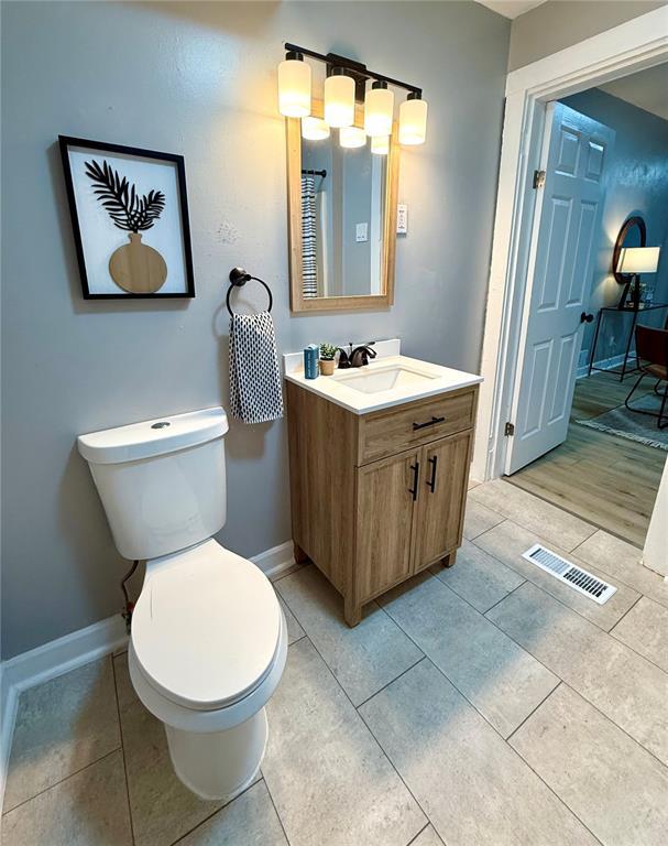 2327 Shirley Ave, Jennings, MO 63136 - bathroom with toilet, vanity, baseboards, and tile patterned floors