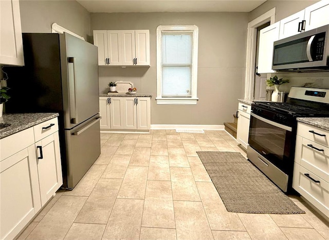 2327 Shirley Ave, Jennings, MO 63136 - kitchen featuring appliances with stainless steel finishes, white cabinetry, and stone counters