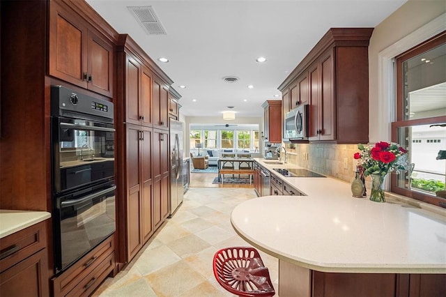 5 Homestead Acres, Olivette, MO 63132 - kitchen featuring black appliances, a sink, recessed lighting, decorative backsplash, and a peninsula