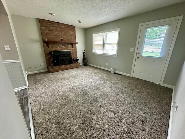 317 Marion Ave, Sikeston, MO 63801 - unfurnished living room featuring plenty of natural light, a textured ceiling, carpet floors, and a fireplace