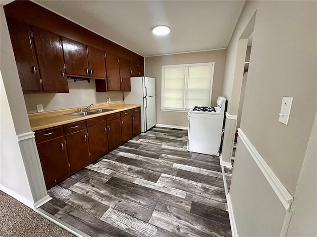 317 Marion Ave, Sikeston, MO 63801 - kitchen with white appliances, a sink, light countertops, dark brown cabinetry, and baseboards