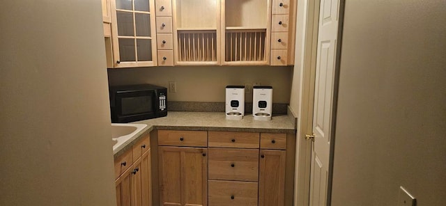 kitchen with black microwave, glass insert cabinets, and light countertops