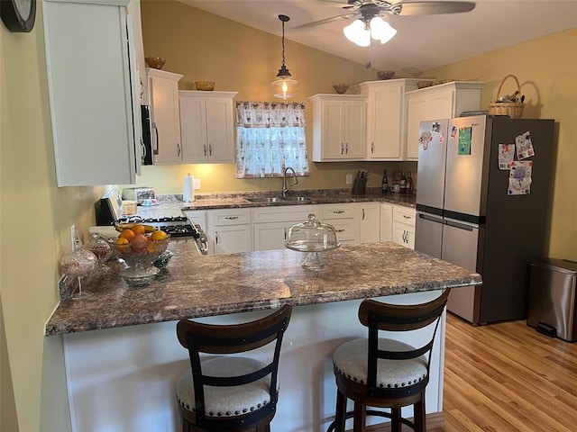 12460 Grassy Hollow Rd, Potosi, MO 63664 - kitchen featuring appliances with stainless steel finishes, a sink, vaulted ceiling, a peninsula, and light wood-type flooring