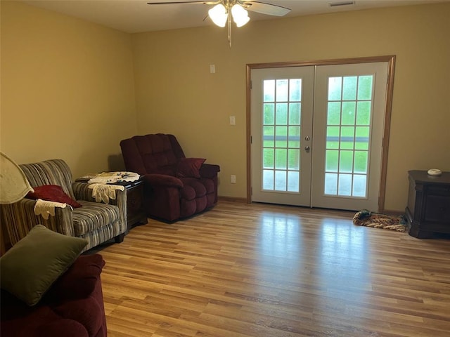 12460 Grassy Hollow Rd, Potosi, MO 63664 - sitting room with light wood finished floors, french doors, a ceiling fan, and a wood stove