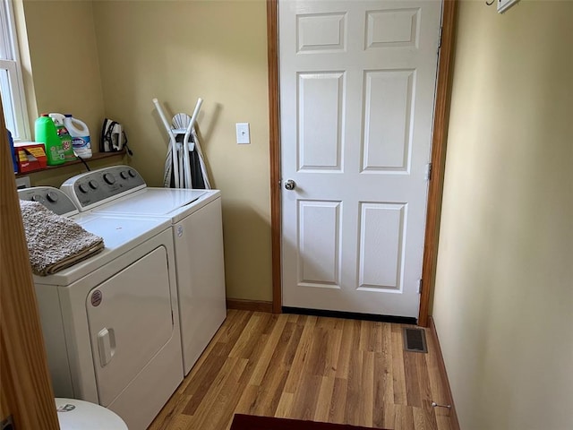 12460 Grassy Hollow Rd, Potosi, MO 63664 - clothes washing area featuring washer and clothes dryer, light wood-style floors, and baseboards