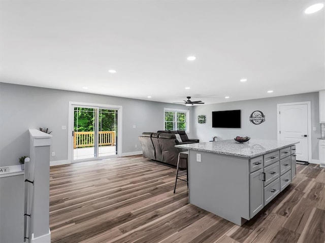kitchen featuring open floor plan, dark wood-style flooring, recessed lighting, ceiling fan, and a center island