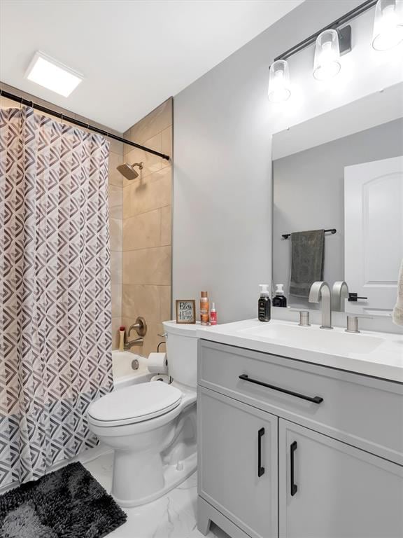 bathroom with toilet, marble finish flooring, vanity, and shower / tub combo with curtain