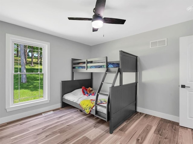 bedroom with light wood-style floors, baseboards, and a ceiling fan