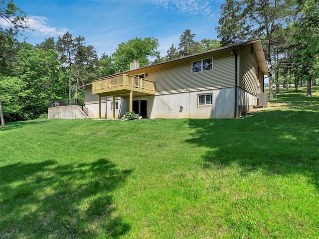 rear view of property with a wooden deck, a lawn, a chimney, and cooling unit