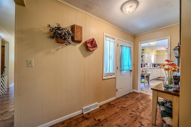310 Smith Rd, Lebanon, MO 65536 - foyer with wood finished floors, crown molding, a textured ceiling, and baseboards