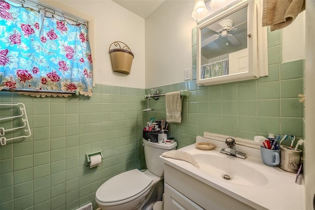 310 Smith Rd, Lebanon, MO 65536 - bathroom featuring toilet, tile walls, vanity, a wainscoted wall, and a ceiling fan