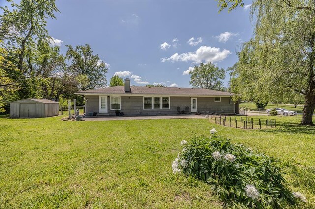 310 Smith Rd, Lebanon, MO 65536 - back of house featuring a patio area, a storage shed, an outdoor structure, and a chimney