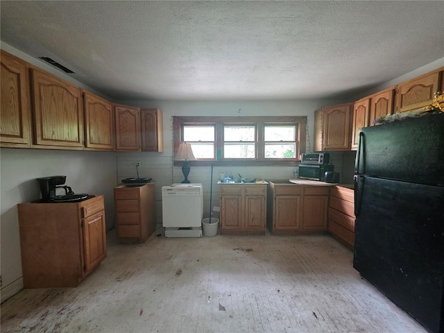 6 Clay St, Park Hills, MO 63601 - kitchen with freestanding refrigerator, brown cabinetry, a textured ceiling, and light wood-style floors