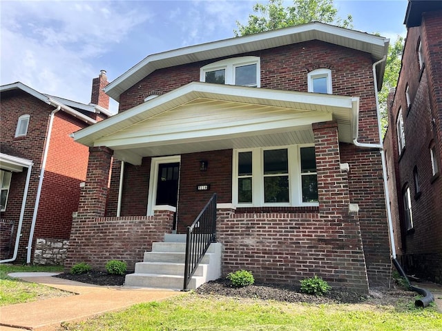 view of front of home featuring brick siding and covered porch