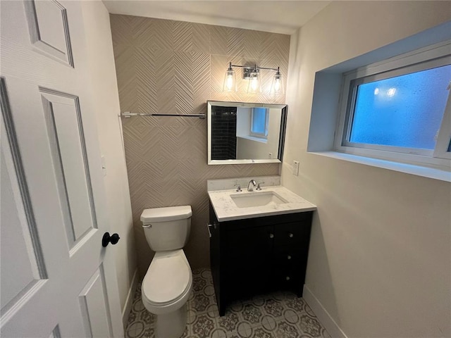bathroom with toilet, vanity, baseboards, and tile patterned flooring