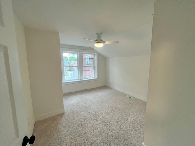 additional living space featuring carpet floors, a ceiling fan, baseboards, and vaulted ceiling