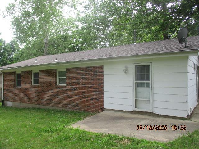 16 Richardson Dr, Union, MO 63084 - view of property exterior featuring a patio area, brick siding, and a lawn