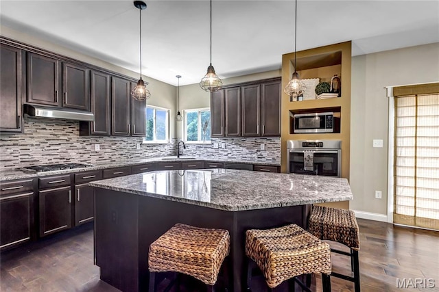 2001 Paul Renaud Blvd, Lake St Louis, MO 63367 - kitchen featuring appliances with stainless steel finishes, a sink, under cabinet range hood, a breakfast bar area, and dark brown cabinetry