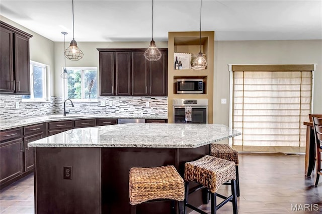 2001 Paul Renaud Blvd, Lake St Louis, MO 63367 - kitchen with appliances with stainless steel finishes, a sink, a kitchen bar, backsplash, and dark brown cabinetry