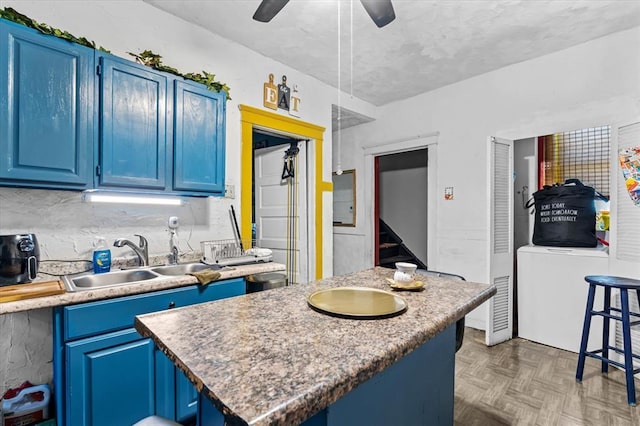 4615 San Francisco Ave, Saint Louis, MO 63115 - kitchen with blue cabinets, ceiling fan, a kitchen island, and light countertops
