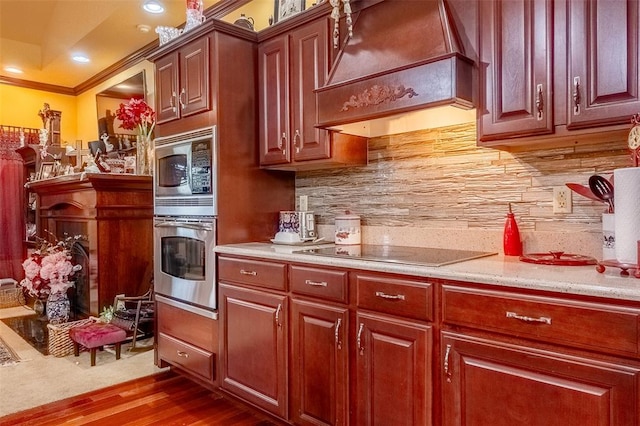 205 Hickman Dr, Bowling Green, MO 63334 - kitchen featuring stainless steel appliances, custom range hood, wood finished floors, crown molding, and decorative backsplash
