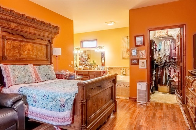 205 Hickman Dr, Bowling Green, MO 63334 - bedroom featuring light wood-style floors, a walk in closet, connected bathroom, and a closet