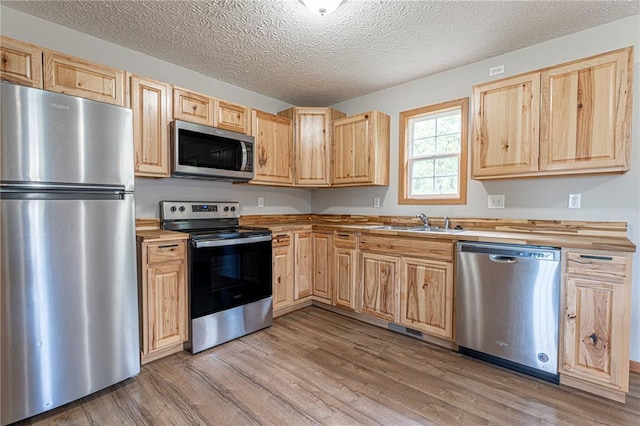 26805 Stephanie Ln, Laquey, MO 65534 - kitchen featuring stainless steel appliances, light brown cabinetry, a sink, light wood-style floors, and wood counters